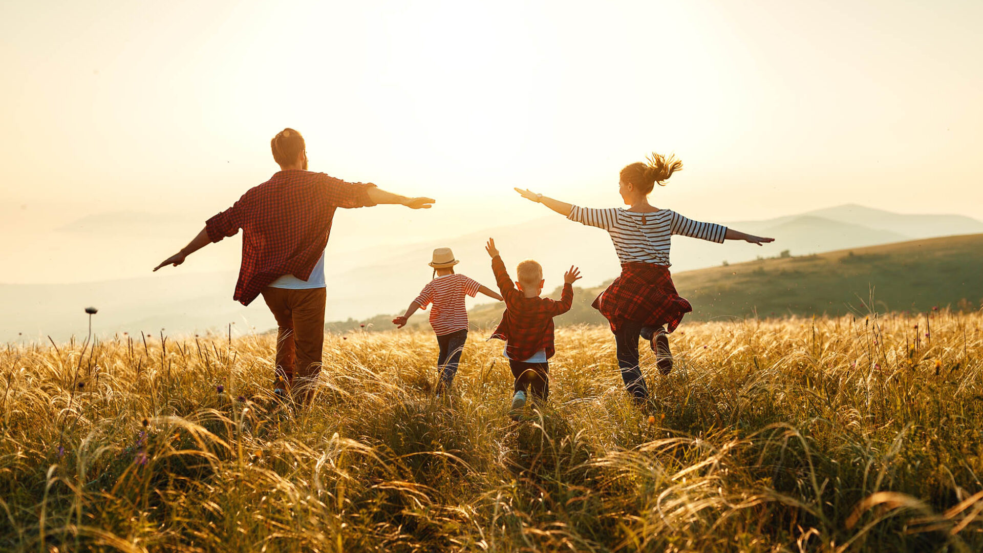 Happy family: mother, father, children son and daughter on sunset